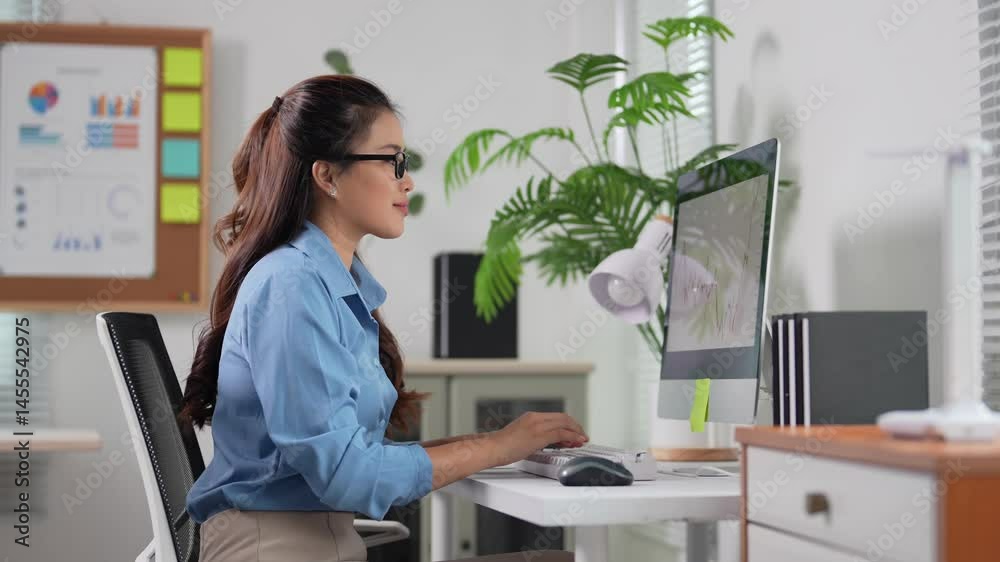 Professional businesswoman working intently at desk, analyzing complex data on computer screen, typing with concentration and efficiency in bright, modern office environment Professional businesswoman working intently at desk, analyzing complex data on computer screen, typing with concentration and efficiency in bright, modern office environment