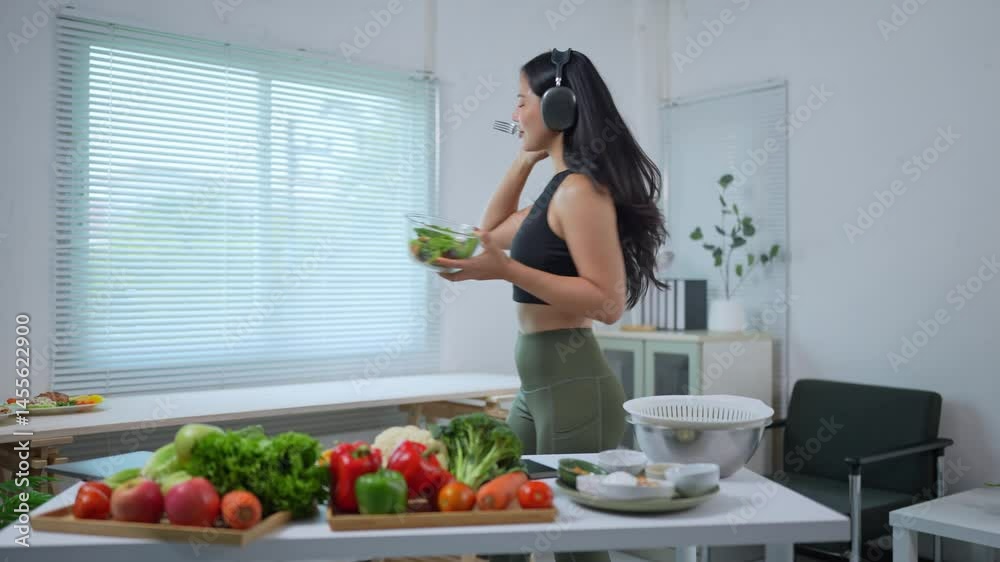 Energetic nutritionist preparing fresh salad, dancing and singing while listening to music, showcasing joyful approach to healthy eating and wellness in bright kitchen space Energetic nutritionist preparing fresh salad, dancing and singing while listening to music, showcasing joyful approach to healthy eating and wellness in bright kitchen space