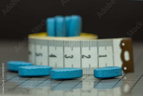 Weight loss pills with a measuring tape: Concept of dietary supplements and slimming medications