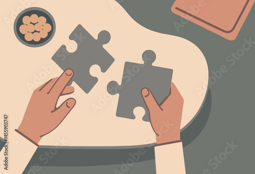 hands fitting puzzle pieces together on table