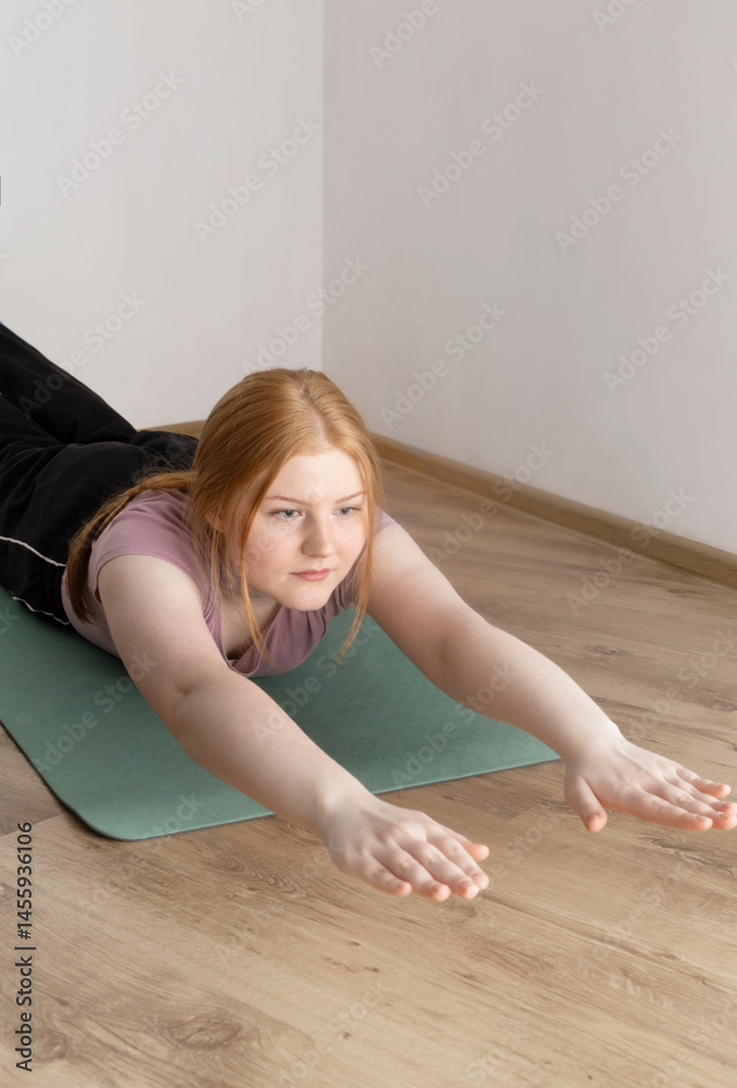 young woman doing physical exercises on the floor at home