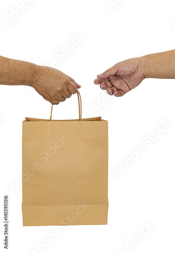 Two hands exchanging brown paper bag, symbolizing transaction or delivery. image captures moment of interaction, focusing on hands and bag against plain background