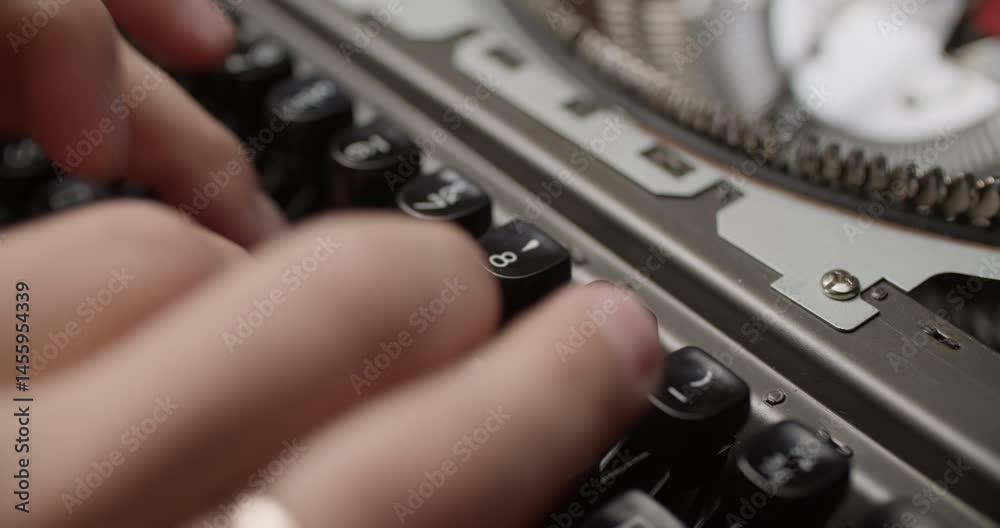 Close-up shot of hands typing on a retro red typewriter. Black and silver keys, fingers curled mid-action, wooden surface, paper in background. Elevated angle with depth.