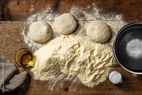 Fototapeta Naklejka Na Ścianę i Meble -  Homemade pizza dough ingredients. flour, water, olive oil and salt, laid out on a rustic wooden table. Italian pizza making.