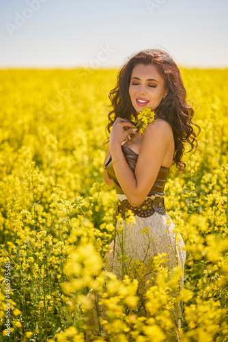 beautiful woman posing in a field of blooming rapeseed