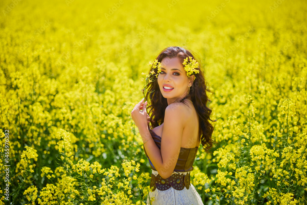 beautiful woman posing in a field of blooming rapeseed