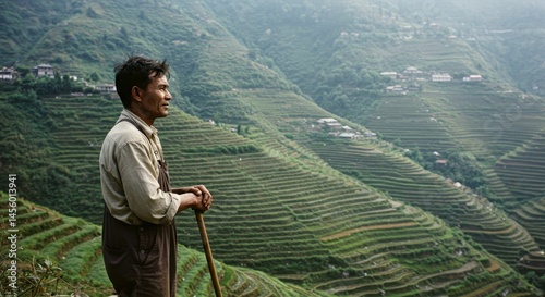Asian man resting in rice field terraces, enjoying the scenic mountain landscape, seeking digital detox and mental clarity on slow living for travel and mental health