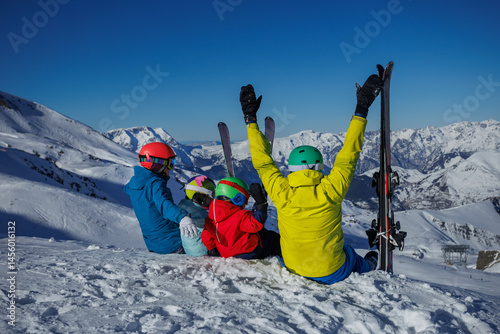 A joyful family lift hand have fun moments in snowy mountain