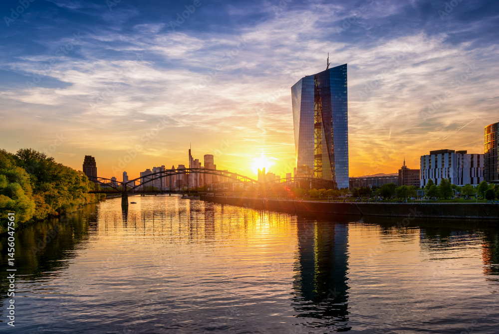 The skyline of Frankfurt am Main, Germany, during a colorful summer sunset with modern finance buildings and reflections in the Main river