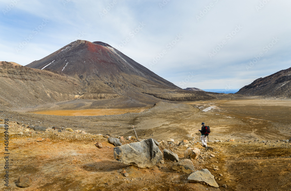 Man hiking Tongariro Alpine Crossing towards Mt Ngauruhoe. Tongariro National Park. New Zealand.