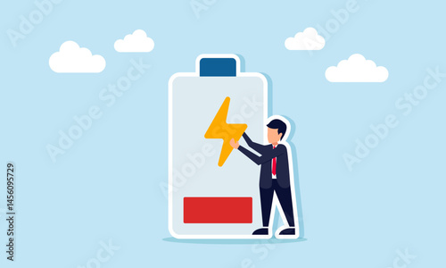 Businessman standing next to a low battery holding an electricity icon, illustration of the need to recharge resources for business and production or work systems