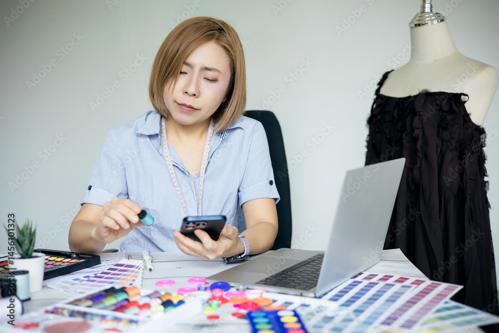 Fototapeta premium Designer is using a smartphone on her desk