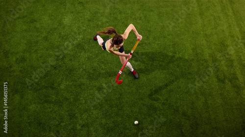 Obraz na plátně High angle view of athlete approaching ball on green grass field against white studio background, showing strategic movement