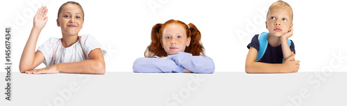 Obraz na płótnie Three thoughtful school children sitting at desk expressing interest curiosity and boredom isolated on transparent background. Concept of childhood, early development w salonie