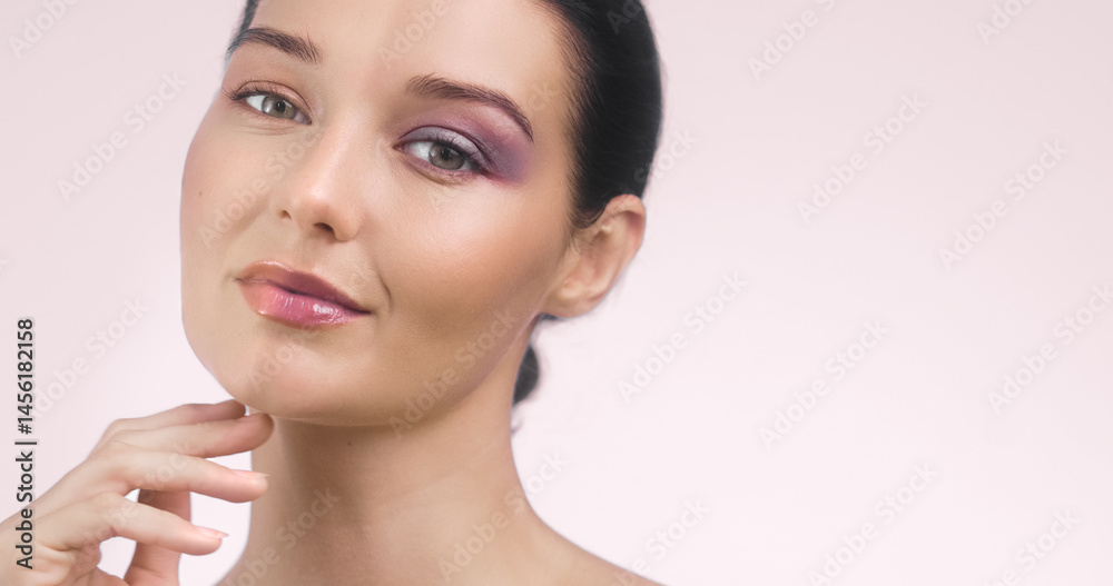 Wide-format banner of a young Caucasian woman showing a half-face makeup concept - one side with vibrant purple eyeshadow and the other natural. Perfect for cosmetics, beauty ads, and tutorials.
