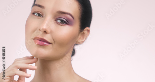 Obraz na płótnie Wide-format banner of a young Caucasian woman showing a half-face makeup concept - one side with vibrant purple eyeshadow and the other natural. Perfect for cosmetics, beauty ads, and tutorials. w salonie