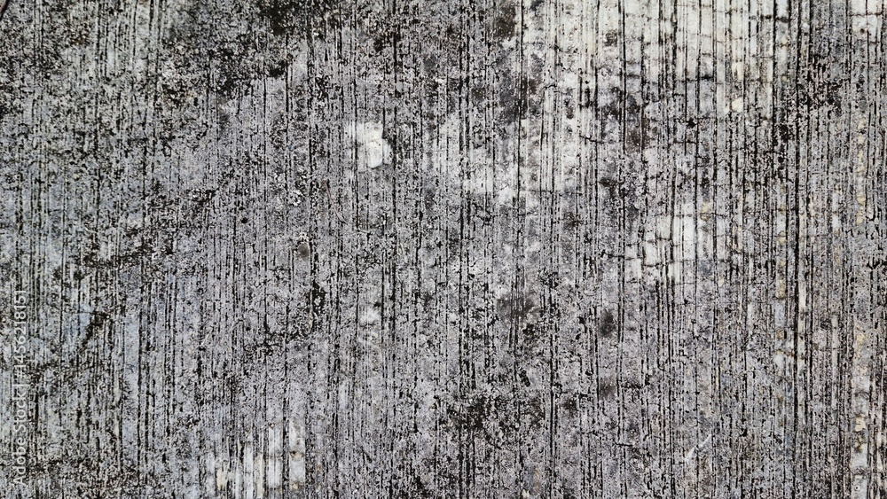 Obraz premium A close-up shot of a weathered concrete surface, showing cracks, imperfections, and a rough texture. This image could be used for backgrounds, textures, and design elements. 
