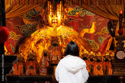 Asian Chinese people praying, Make a wish in front of Mazu or Matsu golden statue in Taiwan Temple photo