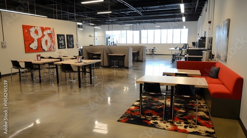 Spacious open-plan workspace with modern furnishings and art.