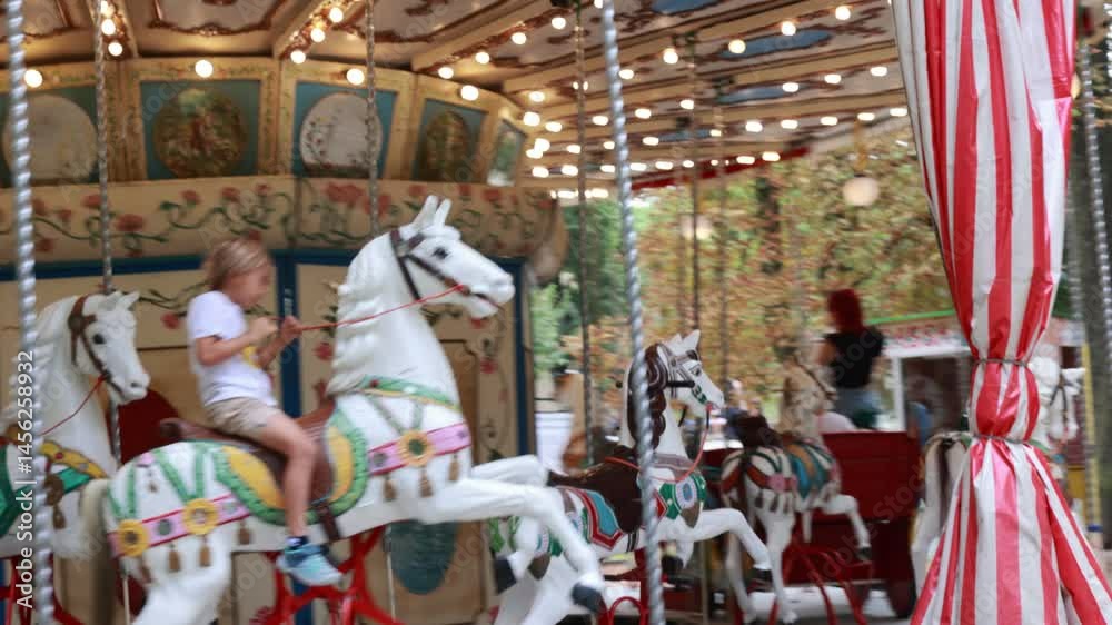 Child, going on Merry Go Round, kids play on carousel in the summer