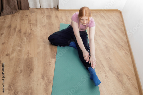 Obraz na płótnie young woman doing physical exercises on the floor at home w salonie
