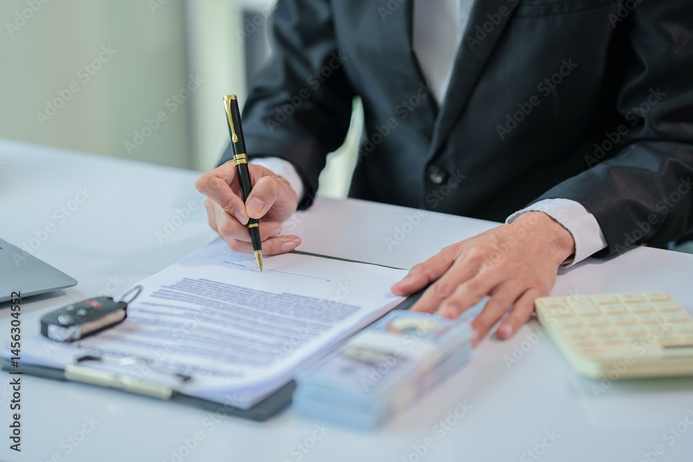 A man is offering a car quote to a customer with a calculator and money on the table. A man is offering a car quote to a customer with a calculator and money on the table.