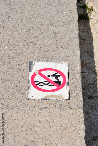 Obraz na płótnie A weathered - No Diving - sign with a red circle and diagonal line over a diving figure is embedded in a concrete surface w salonie