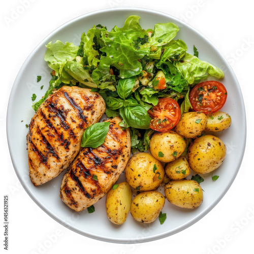 A top down view of grilled chicken breasts with potatoes and salad on a white plate isolated