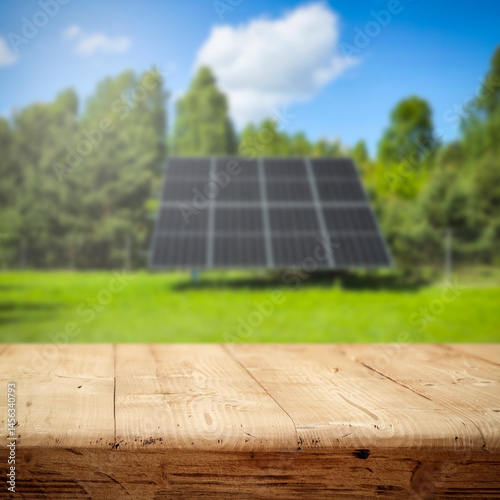 Fototapeta Naklejka Na Ścianę i Meble -  Empty wooden podium with copy space for showcasing eco-friendly or sustainable products and solar panels on lush green field background. Renewable energy and environmental protection concept.