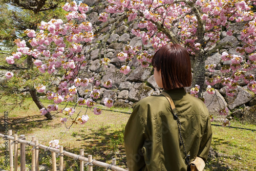 八重桜の下で佇む女性（ヨコ）