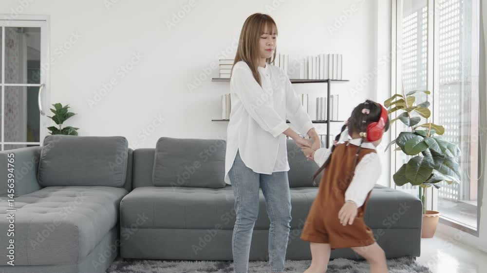 Joyful Child Dancing with Parent in Living Room While Wearing Headphones and Enjoying Music