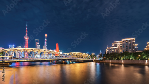 Photography Stunning Nightscape: Illuminated Bridge Over a Reflective River in a Modern City