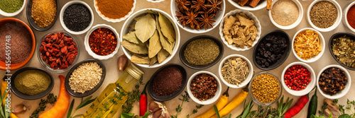 Photography Collection of assorted spices and herbs spread on a beige background, blending e
