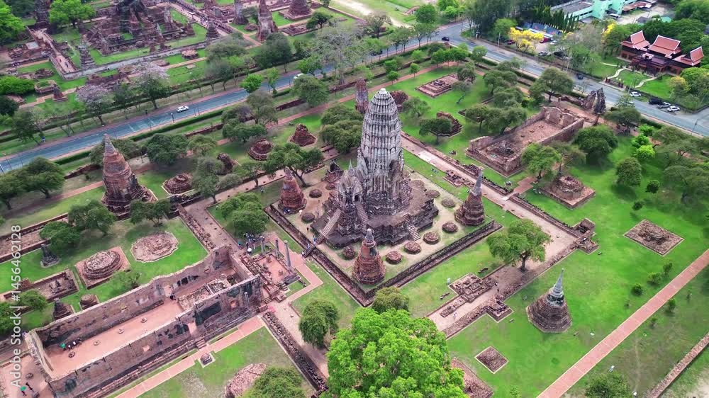 Aerial medium orbit establishing of temple complex and ancient ruins of Ayutthaya, Thailand with surrounding greenery