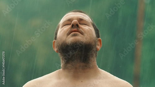 A man yells into the storm, soaked and trembling, his voice carried by wind and rain in a desperate release of pain, passion, and power.