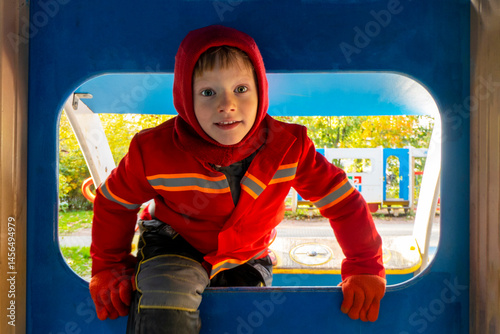 boy is playing on the color playground automne time . High quality photo