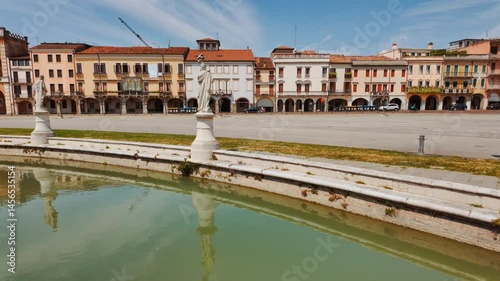 Prato della Valle Square highlights ornate sculptures lining its elliptical layout and green lawns, Padua, Veneto, Italy
