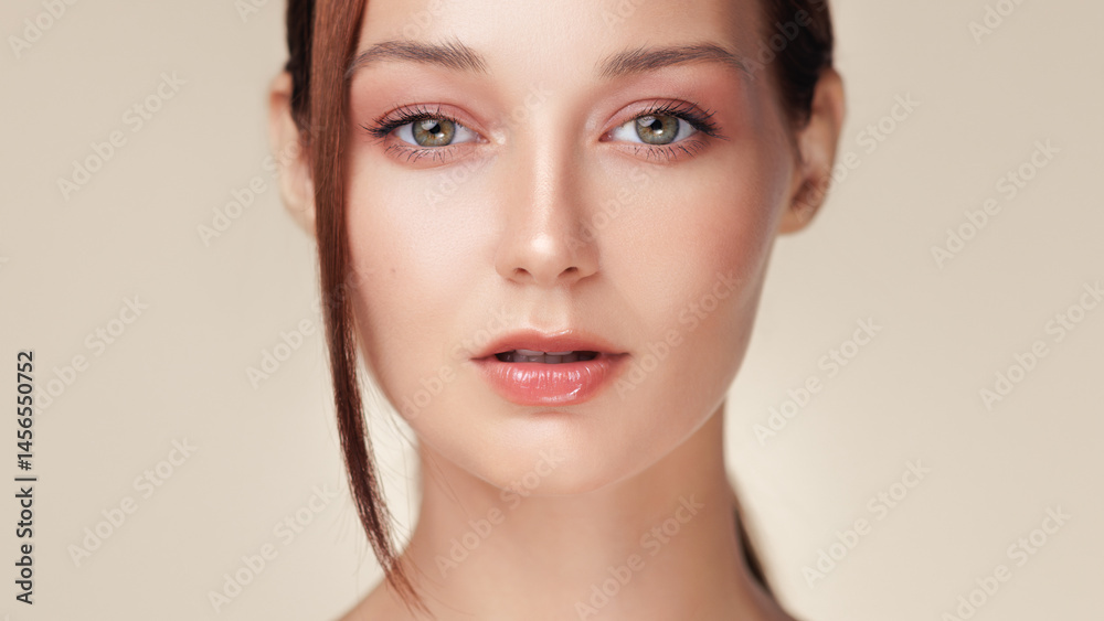 Young woman with glowing skin and peach toned makeup in a close-up studio shot. Great for beauty industry ads, skincare products, or cosmetic promotional banners and editorial content.