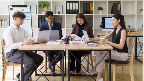 Business team in a creative workspace reviewing data and brainstorming during a team meeting.