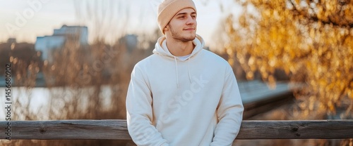 Young man in hoodie outdoors casual fashion style autumn season calmness serene urban background