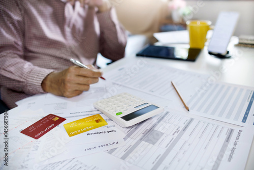 asian men calculating expenses and stressed about credit card debt and many bills and then money not enough for paying debts, select focus at credit card and bank statement