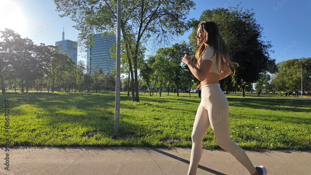Young woman running and jogging in urban park.