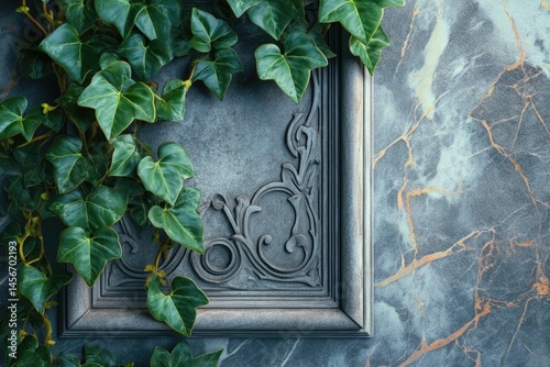 Ornate gray frame with lush green ivy leaves on a marble background.
