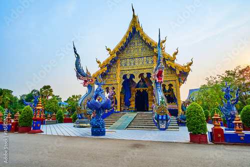 Facade of the Ubosot with Naga serpents in Wat Rong Suea Ten, Chiang Rai, Thailand photo