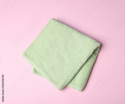 Clean towel on pink background, top view