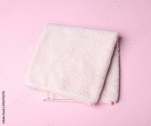 Clean towel on pink background, above view