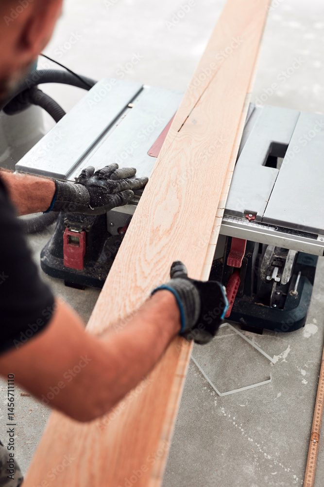 Professional handyman installing laminate flooring in a new apartment.