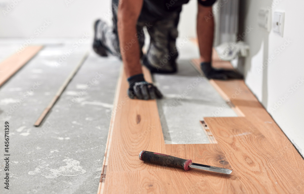 Professional handyman installing laminate flooring in a new apartment.