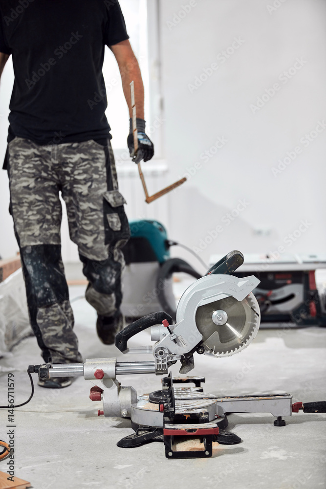 Professional handyman installing laminate flooring in a new apartment.