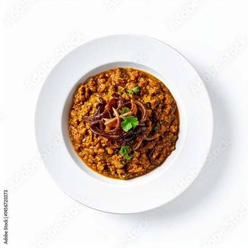 Delicious curry dish, expertly plated with onions and herbs atop a white plate. A flavorful meal